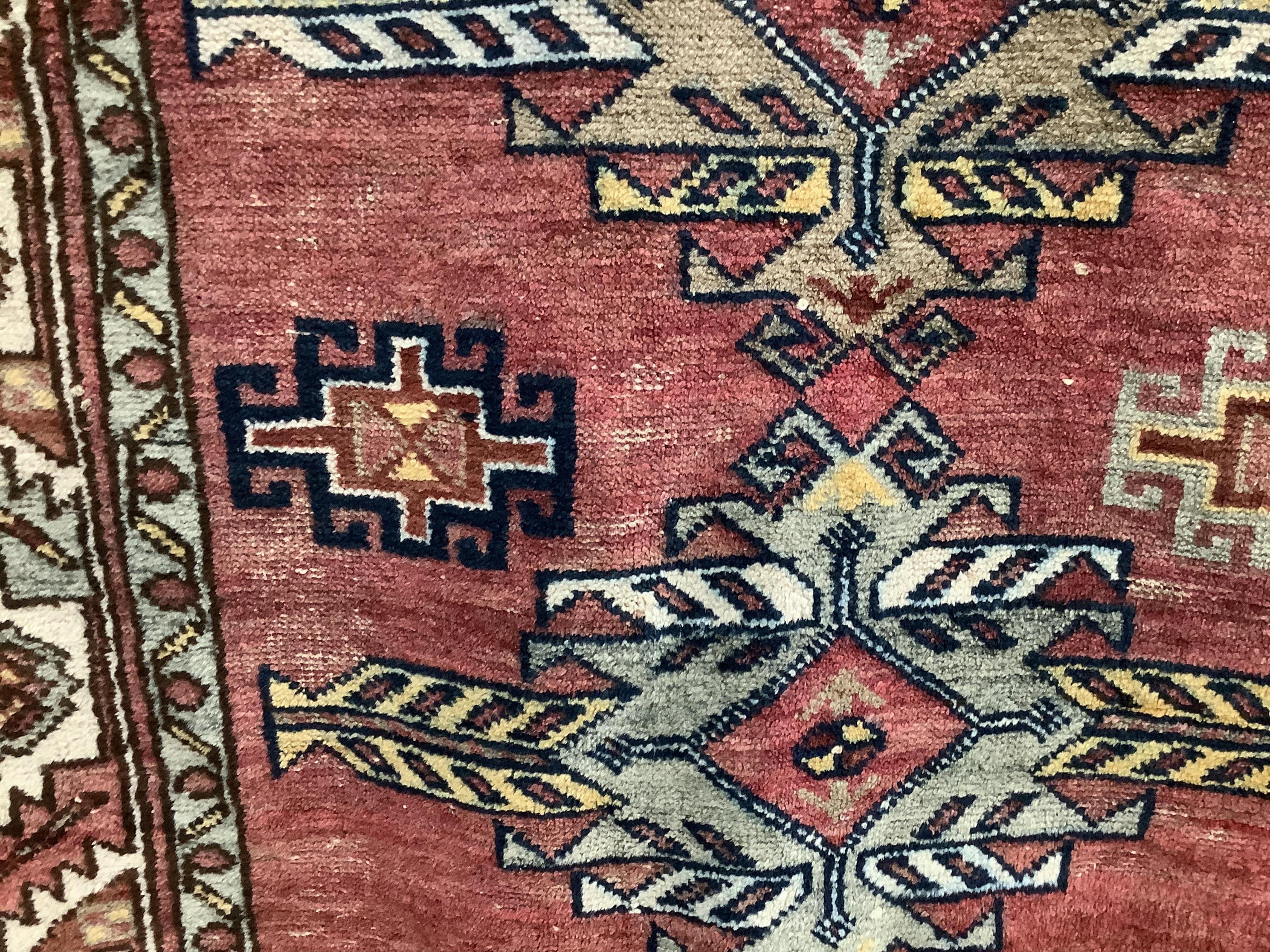 A Caucasian style red ground rug, 210 x 120cm. Condition - fair